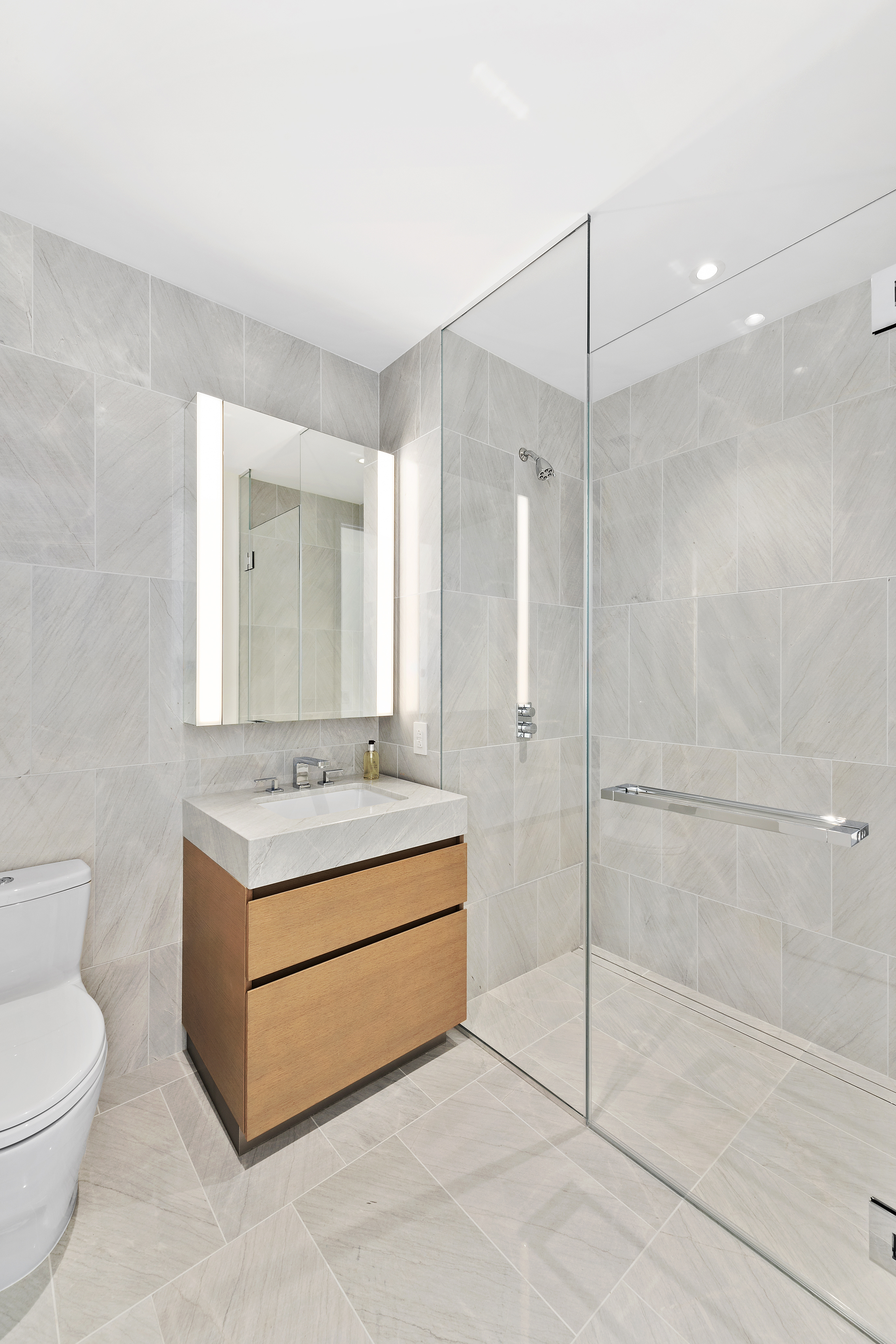 15 Hudson Yards, Unit 75A Manhattan, NY 10001 - Photo 8 of 31 a bathroom with a sink a toilet and a mirror