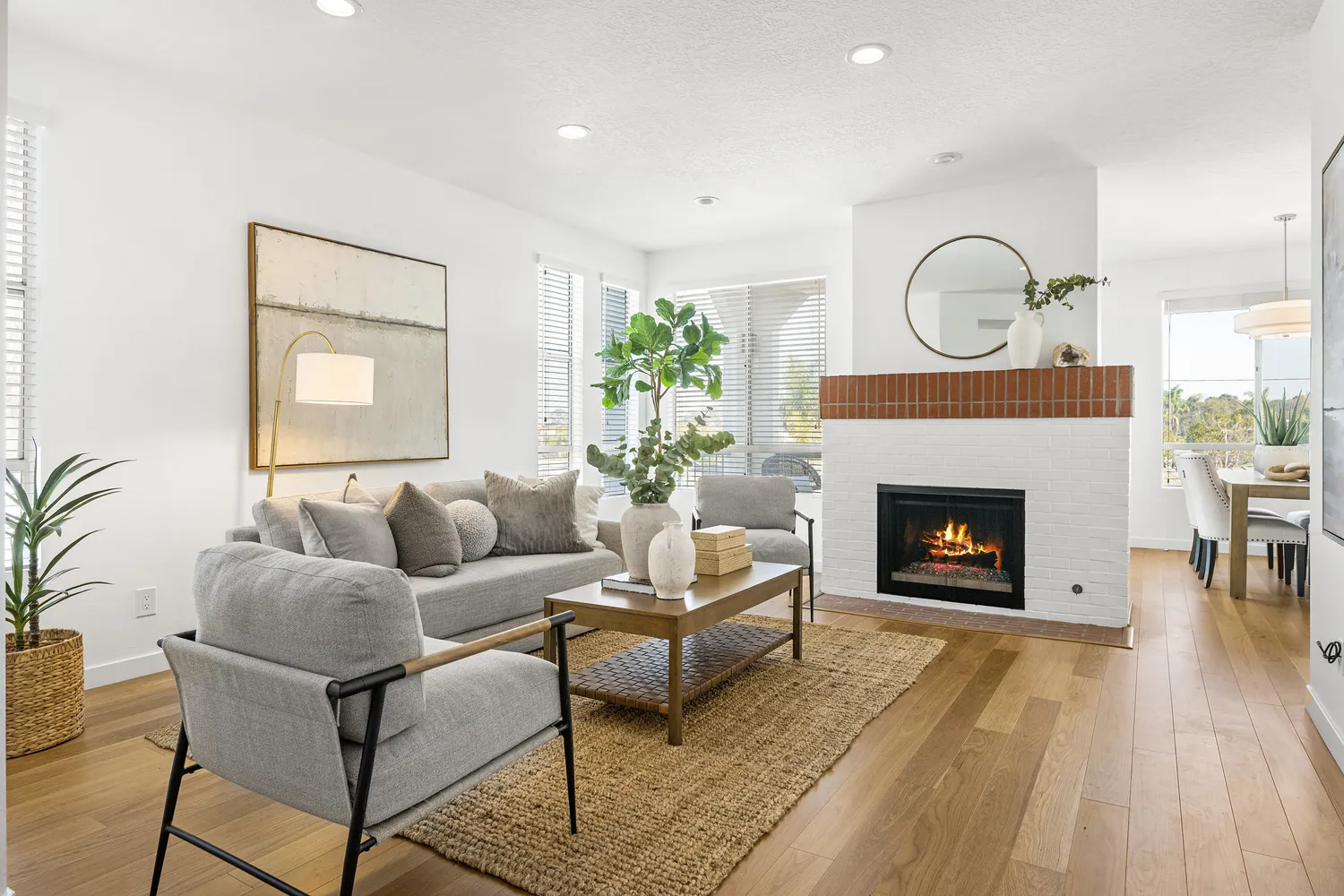 a living room with furniture a fireplace and a potted plant