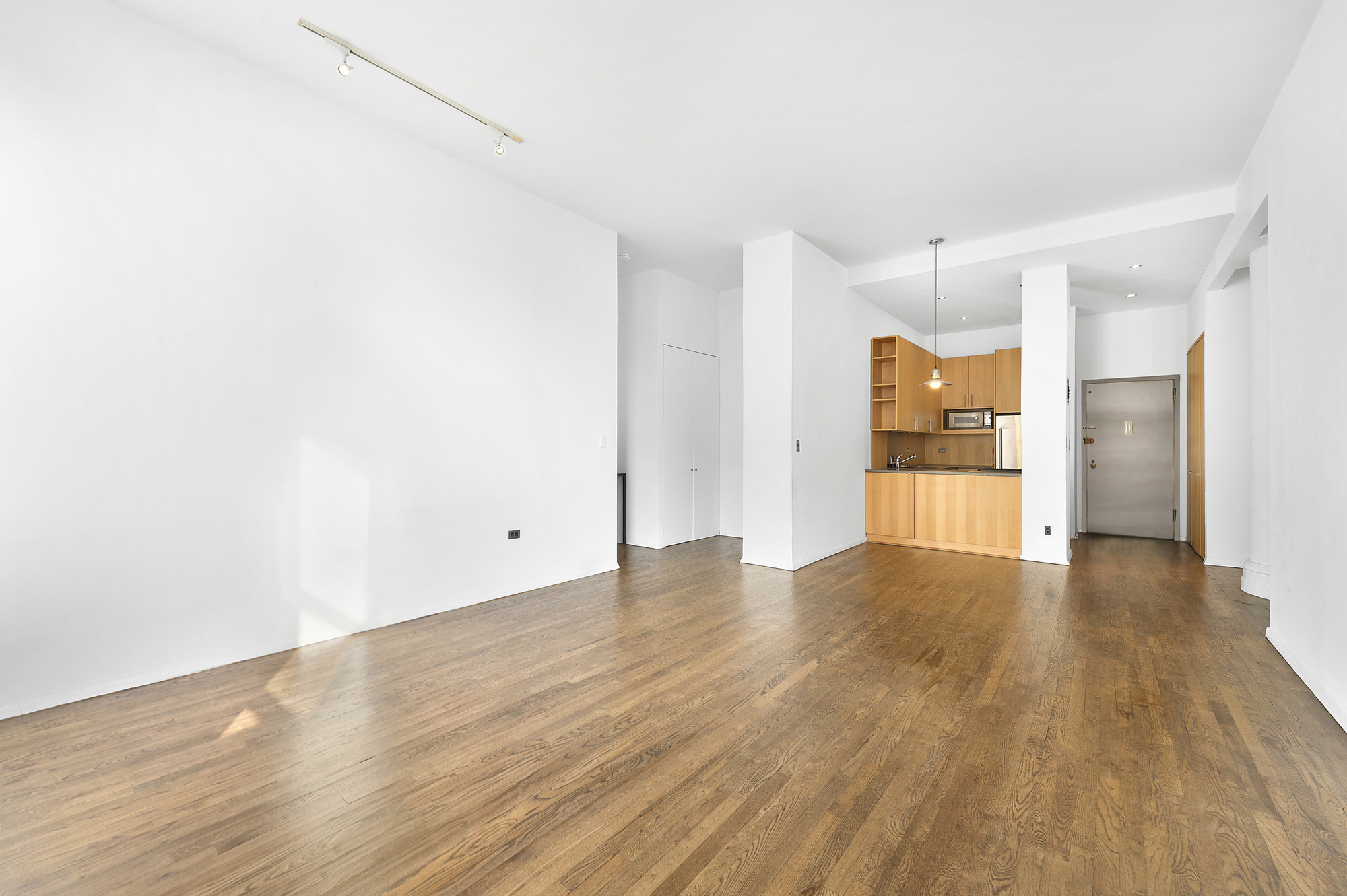 250 Mercer Street, Unit D603 Manhattan, NY 10012 - Photo 3 of 20 a view of an empty room with wooden floor and a window
