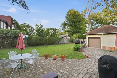 a view of backyard with table and chairs and potted plants