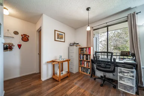 a view of a workspace with furniture and a window