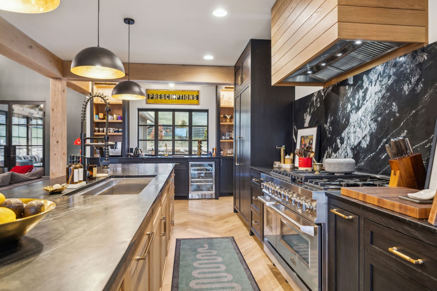 a kitchen with stainless steel appliances granite countertop a sink a stove and a wooden floors
