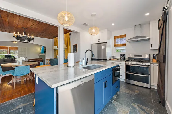 a kitchen with stainless steel appliances granite countertop a sink stove and refrigerator