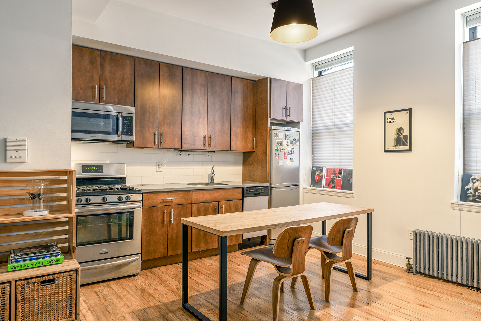 a kitchen with stainless steel appliances a stove a sink dishwasher and microwave with wooden floor