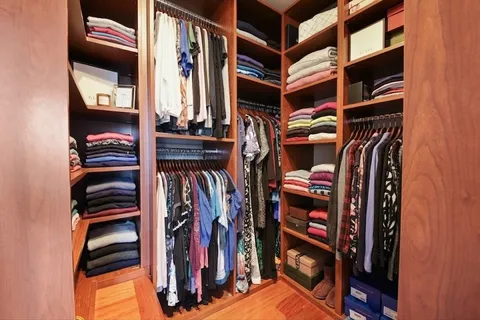 a view of walk in closet with clothes and shoes