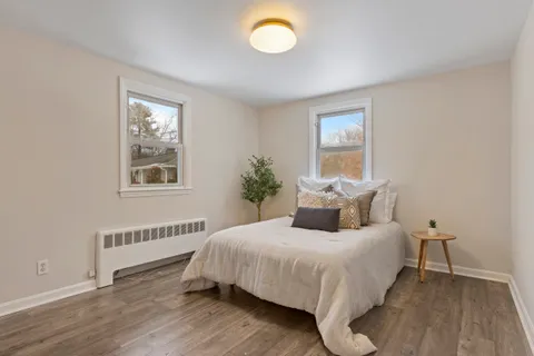 a bedroom with a bed and wooden floor