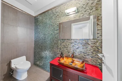 a bathroom with a toilet sink and mirror