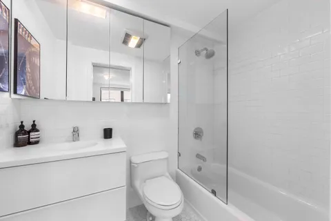 a bathroom with a sink a toilet and shower