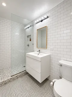a bathroom with a sink mirror vanity and toilet