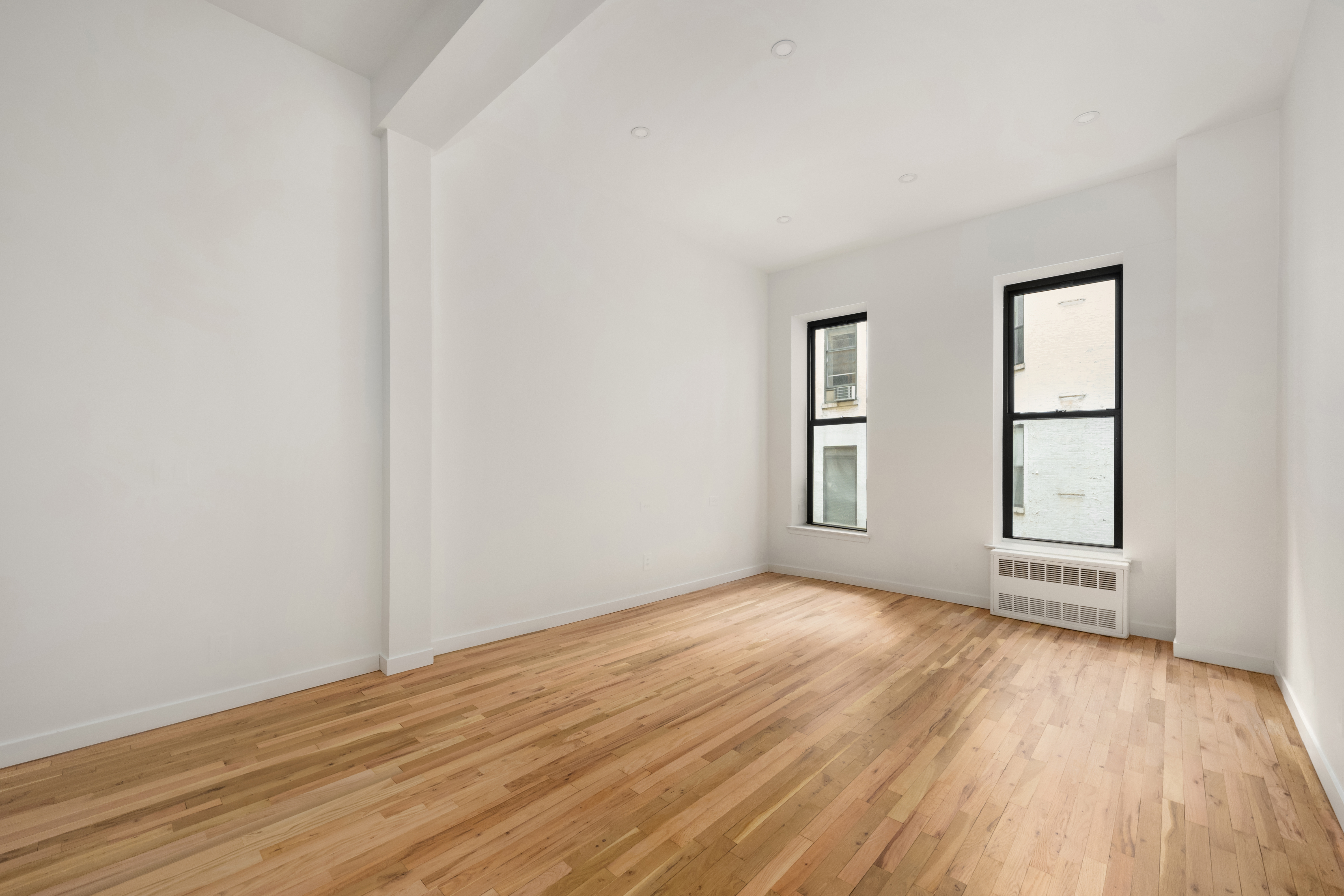 23 East 10th Street, Unit 3F Manhattan, NY 10003 - Photo 8 of 18 an empty room with wooden floor and windows