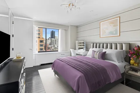 a bed room with a bed window and a television