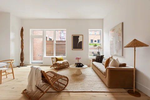 a living room with furniture large window and a wooden floor
