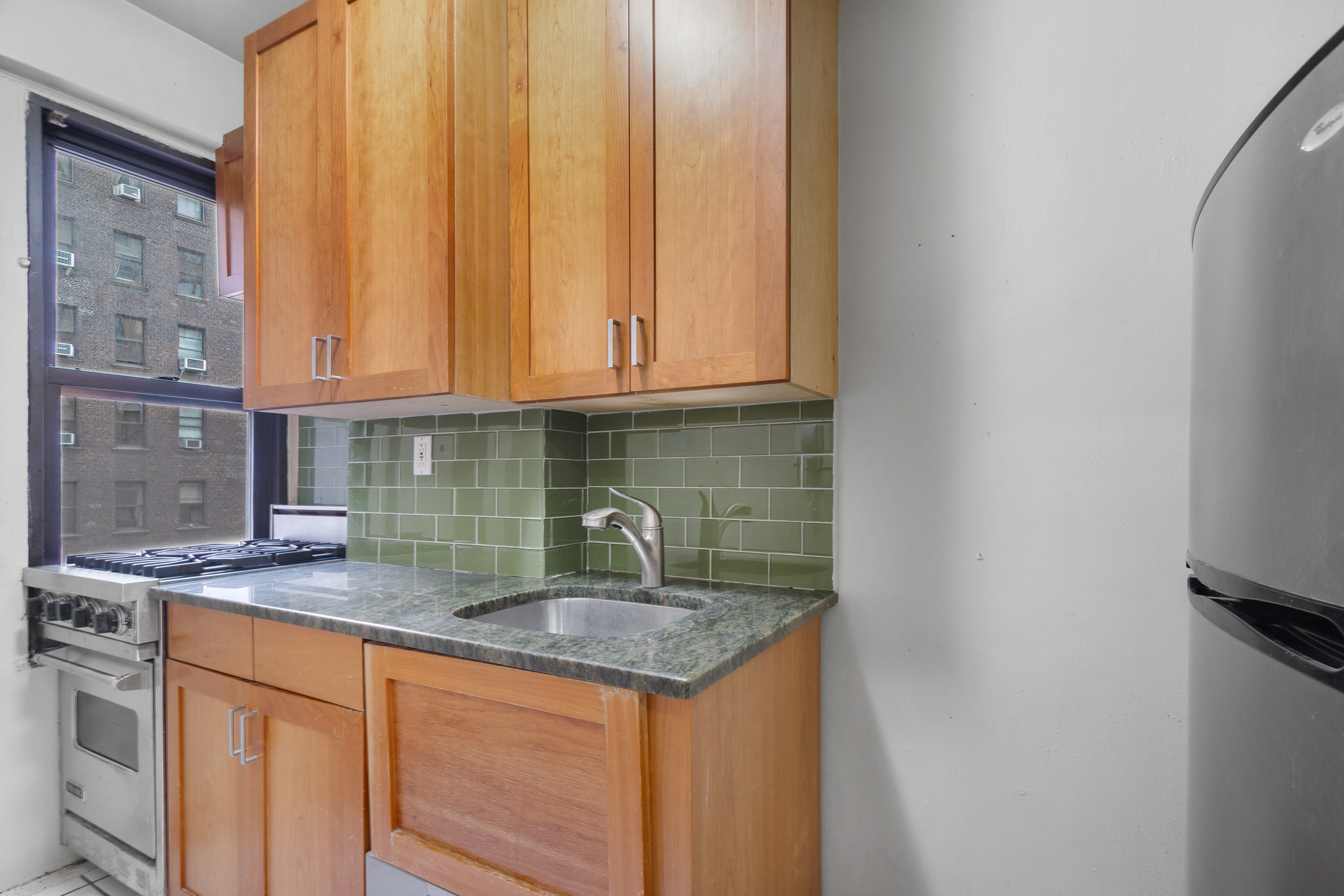 235 West End Avenue, Unit 8G Manhattan, NY 10023 - Photo 8 of 13 a kitchen with stainless steel appliances granite countertop a sink stove and cabinets