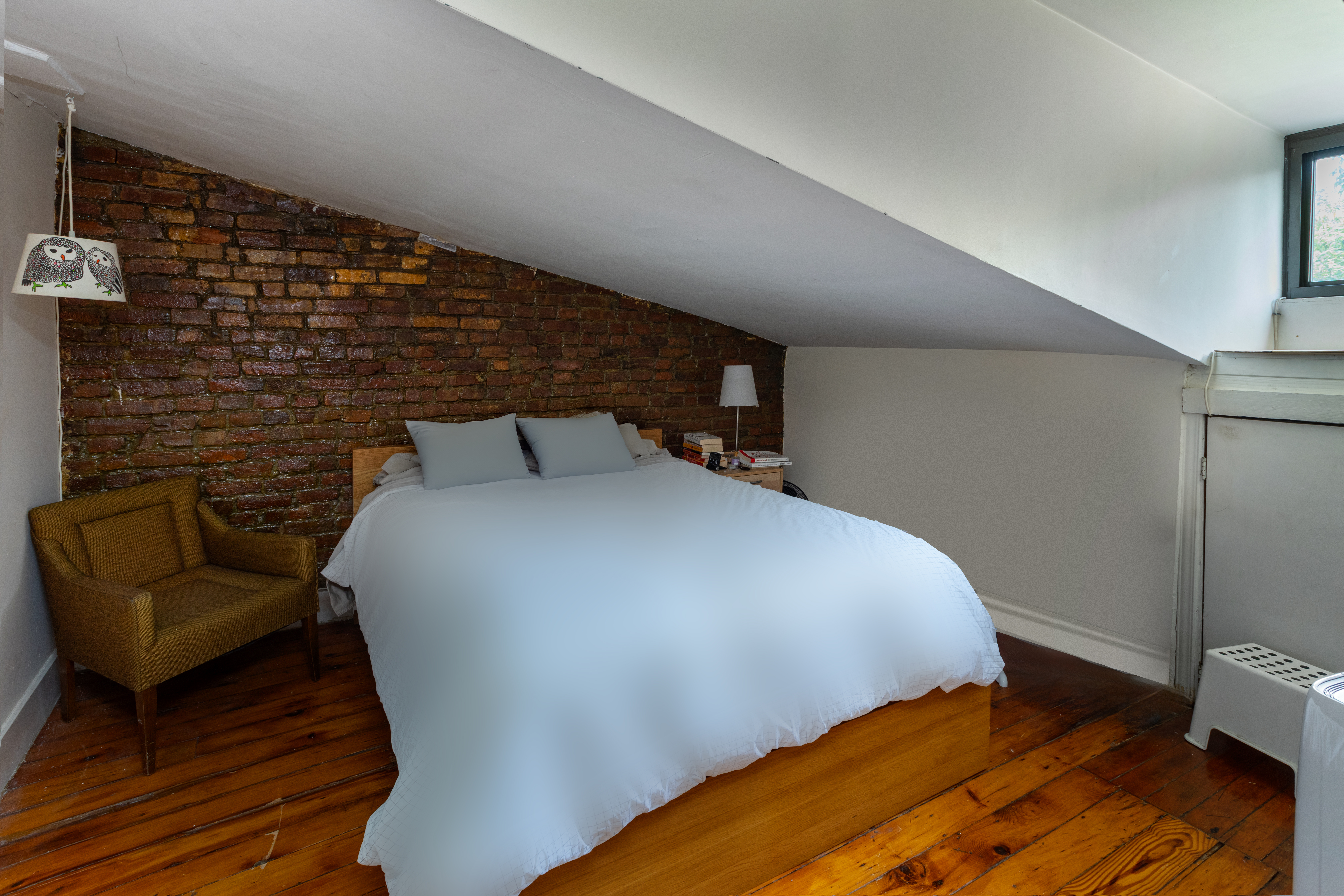 73 Monroe Street Brooklyn, NY 11216 - Photo 13 of 14 a bed sitting in a bedroom next to a window