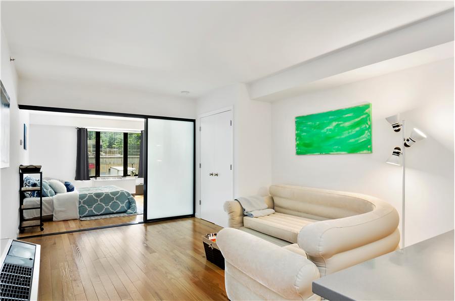 189 Avenue C, Unit 2C Manhattan, NY 10009 - Photo 2 of 10 a living room with furniture and a flat screen tv