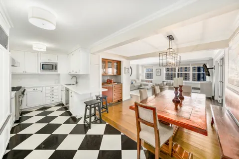 a dining room with a black white checkered floor with a dining table and chairs