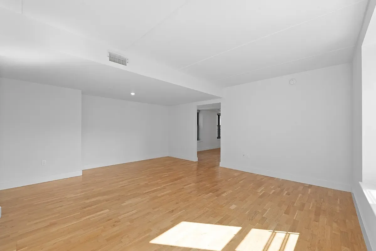 a view of an empty room and wooden floor