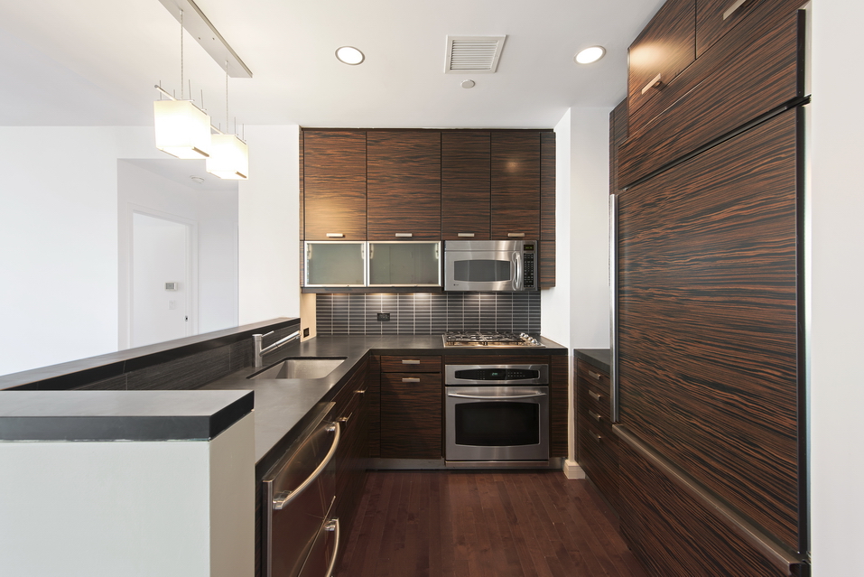 101 West 24th Street, Unit 26A Manhattan, NY 10011 - Photo 3 of 21 a kitchen with granite countertop a stove and a refrigerator