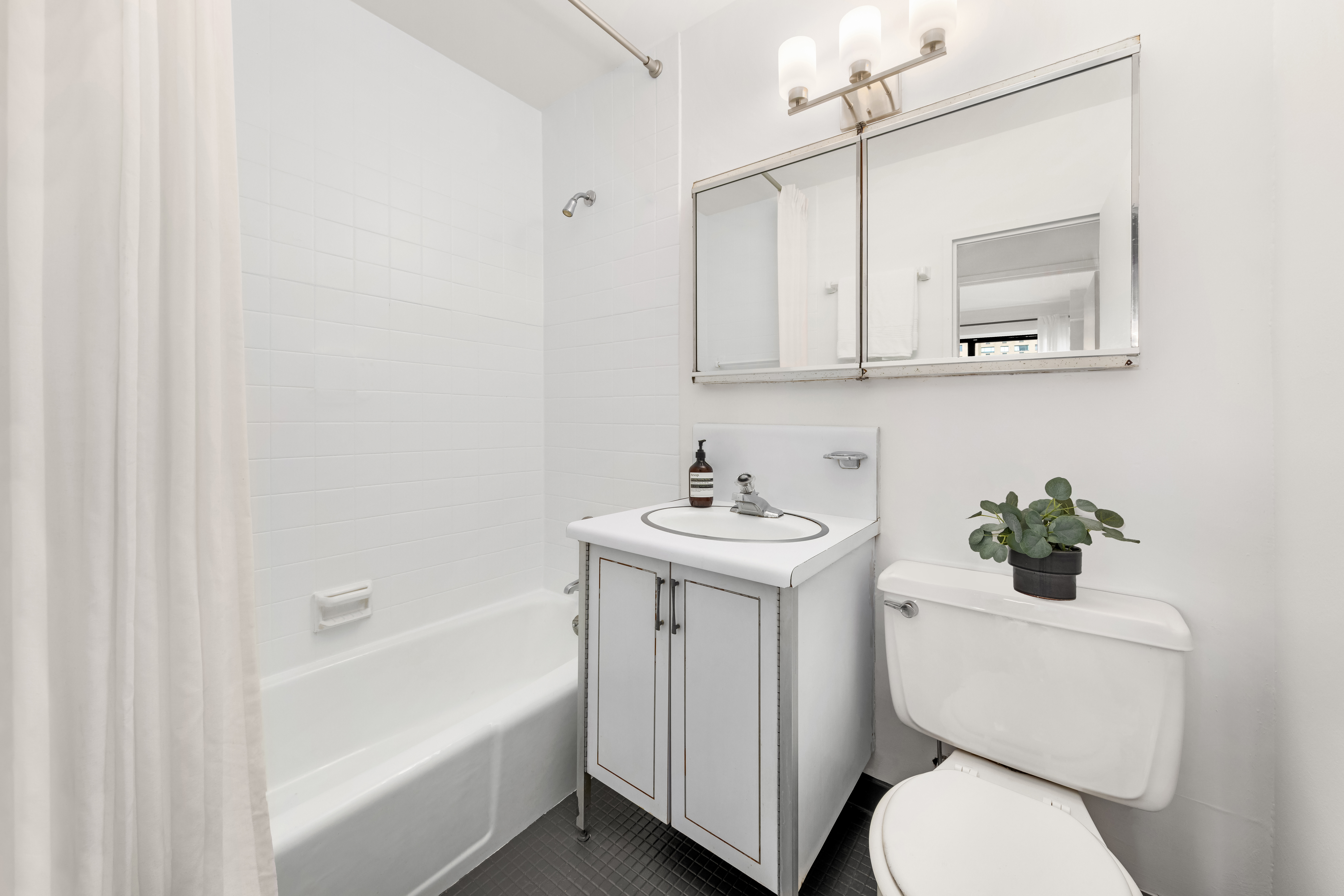 250 East 87th Street, Unit 6E Manhattan, NY 10128 - Photo 6 of 12 a bathroom with a sink a toilet and shower