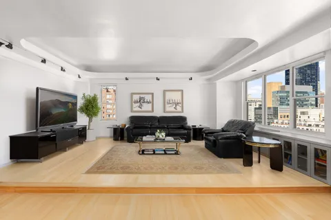 a living room with furniture a flat screen tv and large window