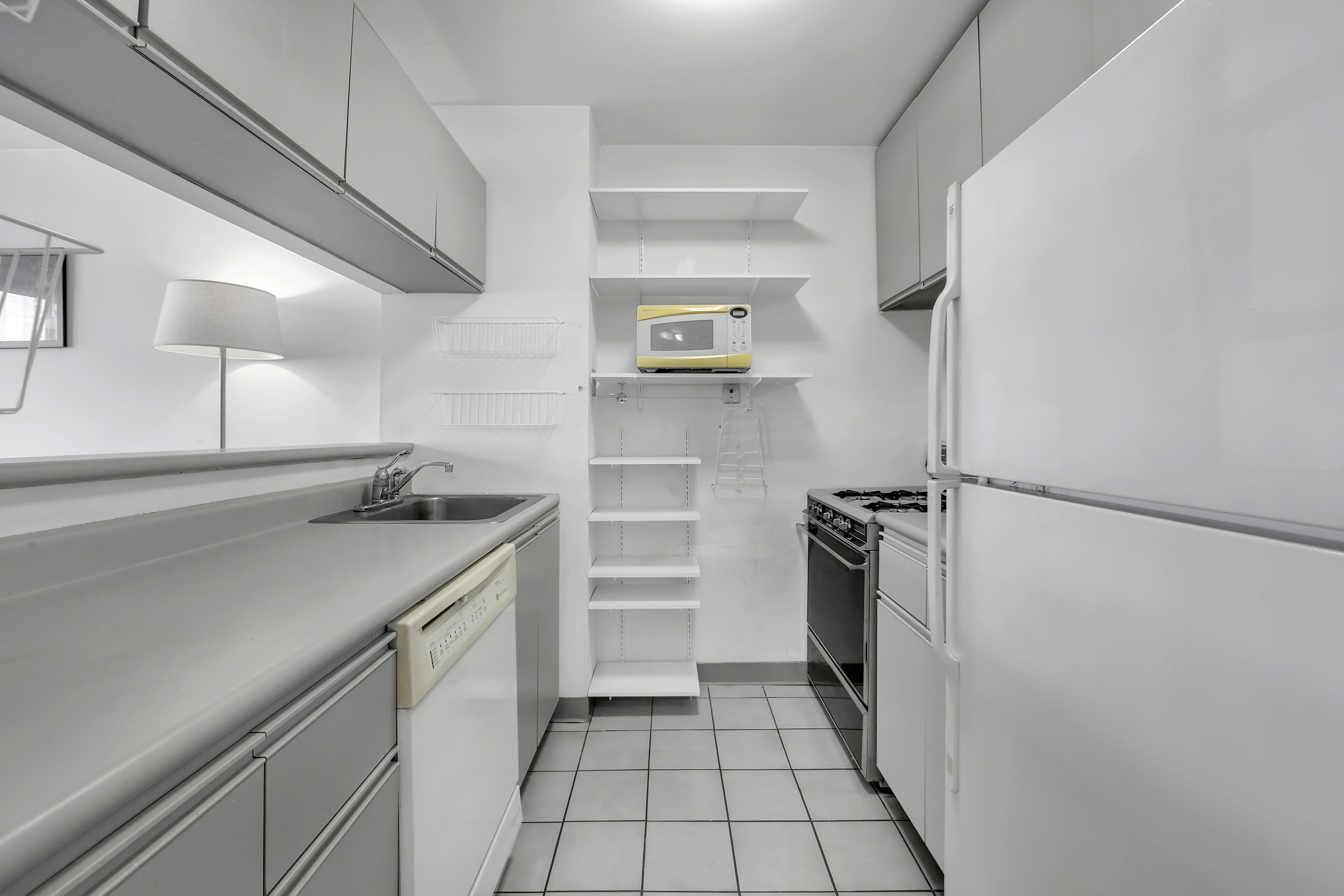 330 East 75th Street, Unit 8H Manhattan, NY 10021 - Photo 4 of 11 a kitchen with a refrigerator and a sink