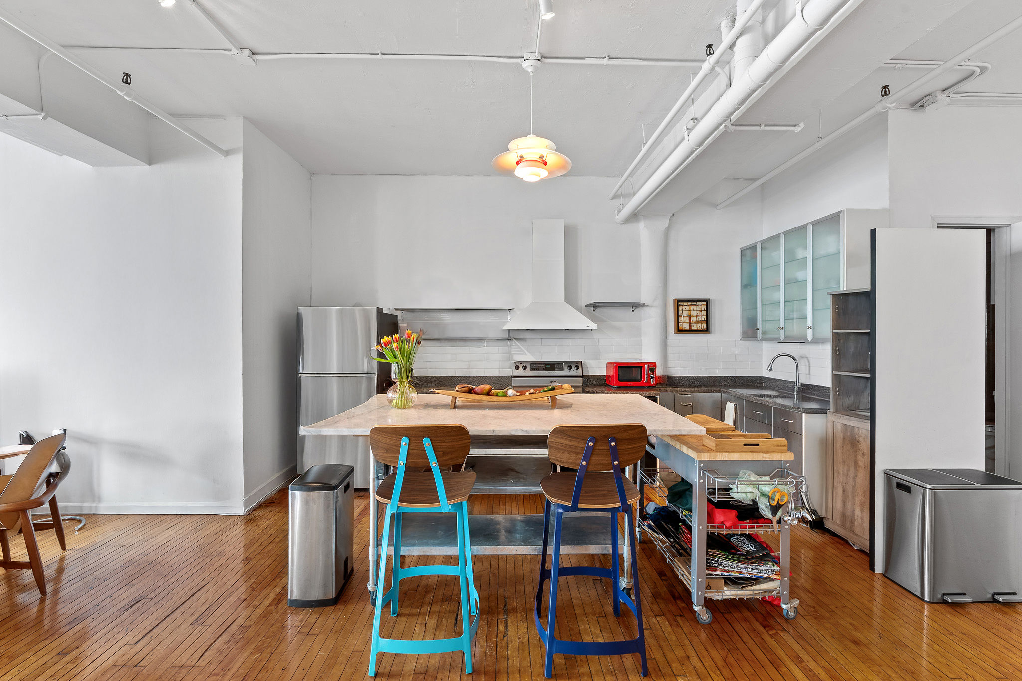 565 Broadway, Unit 8W Manhattan, NY 10012 - Photo 5 of 23 a view of a dining room with furniture wooden floor and chandelier