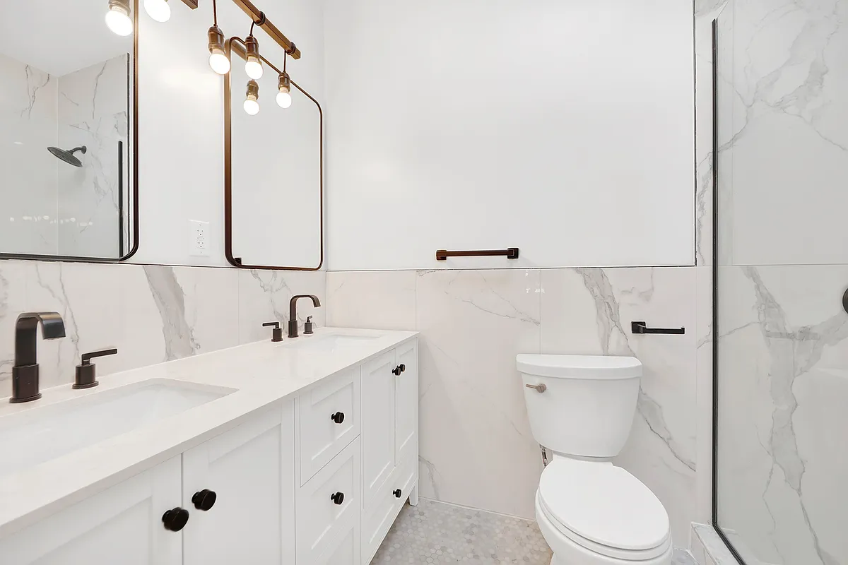 297 Howard Avenue, Unit 2 Brooklyn, NY 11233 - Photo 6 of 13 a bathroom with a toilet sink and mirror