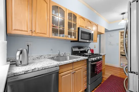 a kitchen with stainless steel appliances granite countertop a sink stove and cabinets