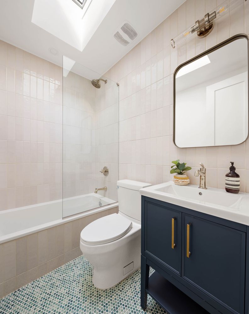 a bathroom with a sink toilet a mirror and shower