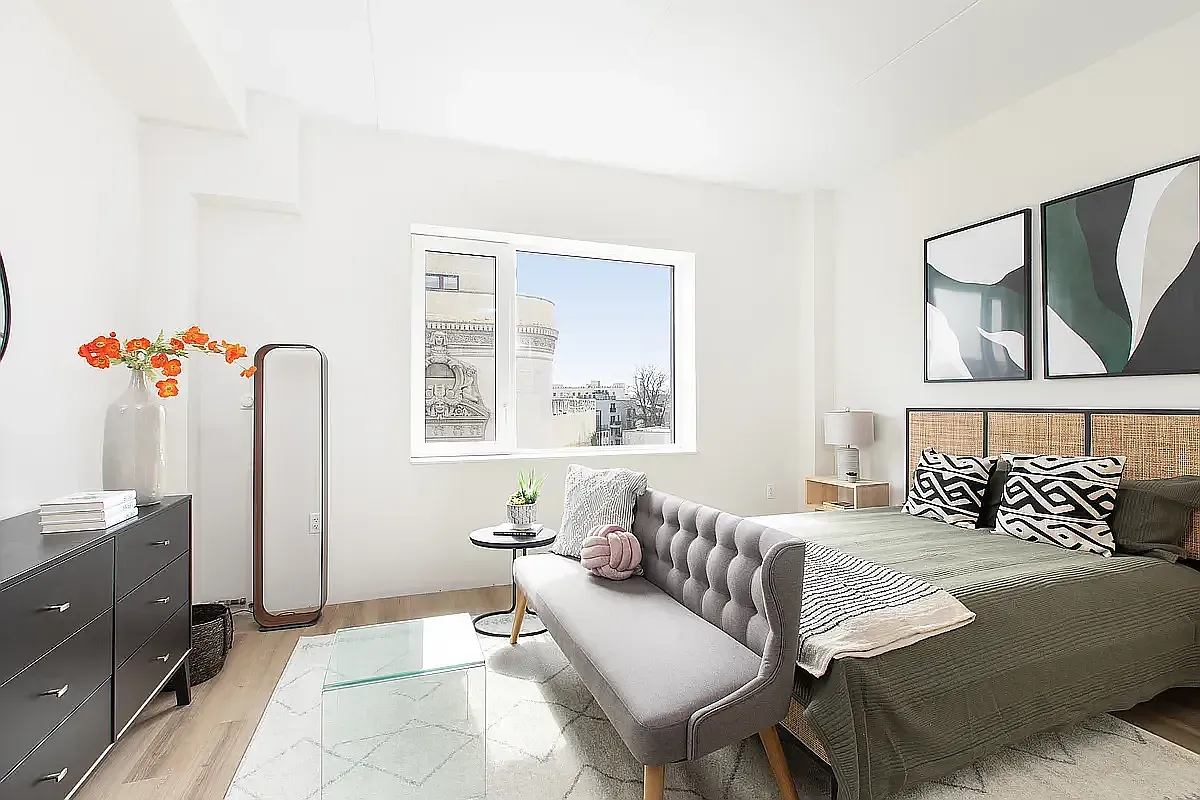 a bedroom with a bed dresser and a window