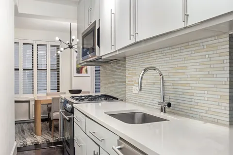 a kitchen with granite countertop a sink and a stove
