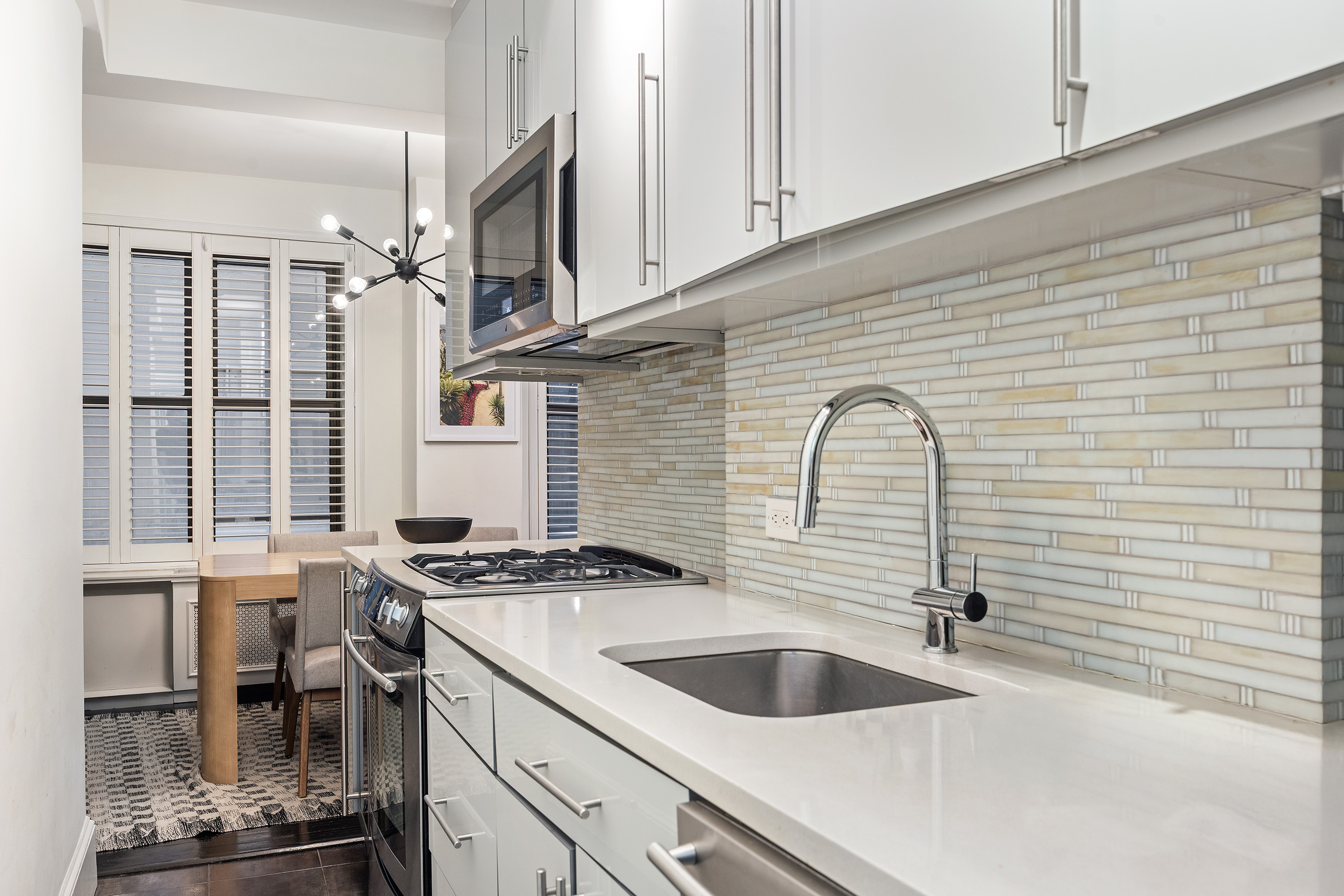 325 East 79th Street, Unit 6C Manhattan, NY 10075 - Photo 7 of 17 a kitchen with granite countertop a sink and a stove