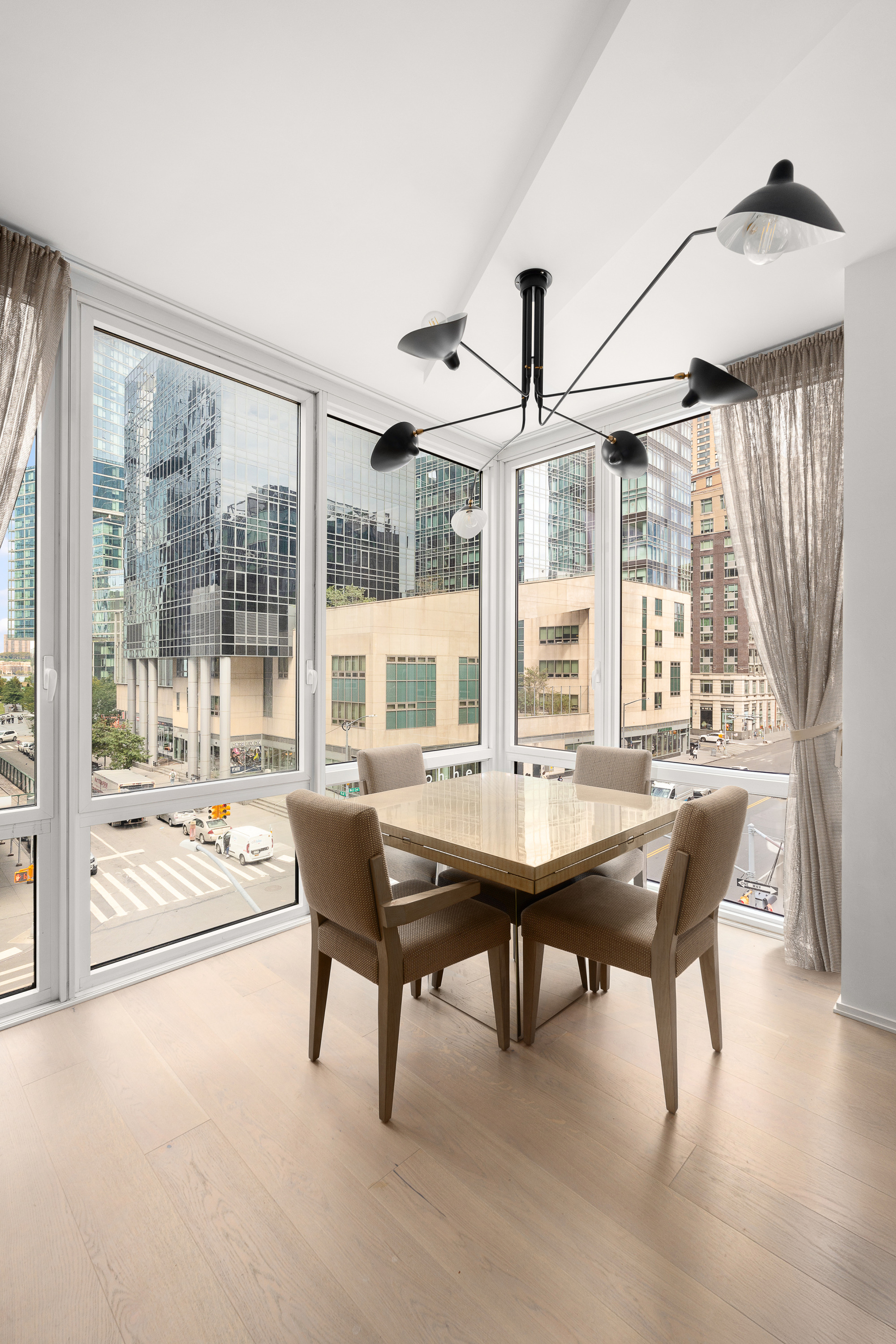 10 West End Avenue, Unit 4B Manhattan, NY 10023 - Photo 4 of 12 a dining room with furniture large windows and a chandelier