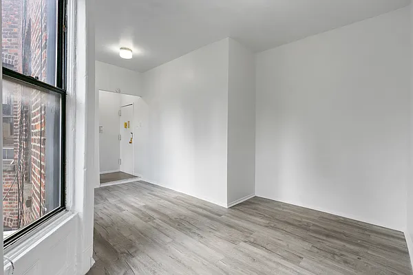 824 9th Avenue, Unit 5RN Manhattan, NY 10019 - Photo 4 of 11 a view of an empty room with wooden floor and a window