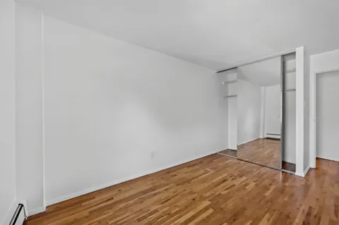a view of empty room with wooden floor