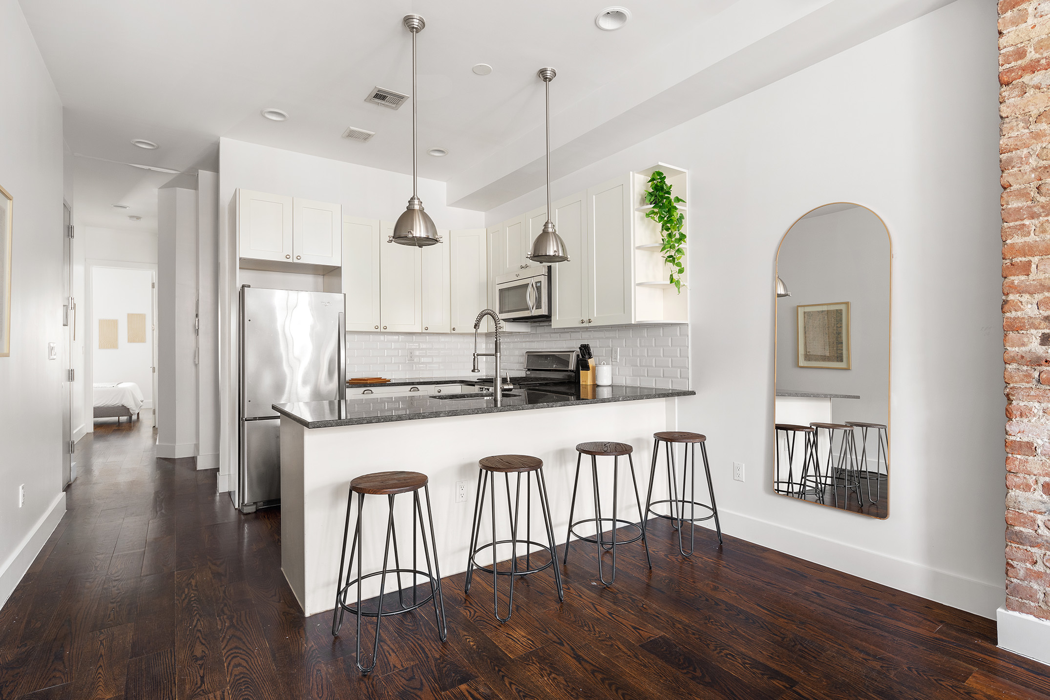 253 Wyckoff Avenue, Unit 2 Brooklyn, NY 11237 - Photo 3 of 8 a kitchen with stainless steel appliances granite countertop a refrigerator a stove a sink dishwasher with a dining table and chairs with wooden floor