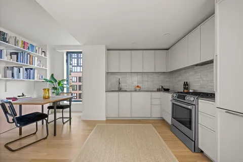 a kitchen with stainless steel appliances a stove a refrigerator sink cabinets and furniture