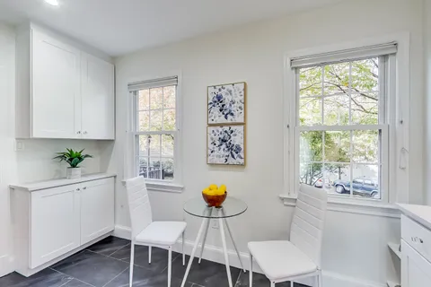 a kitchen with a table chairs and window