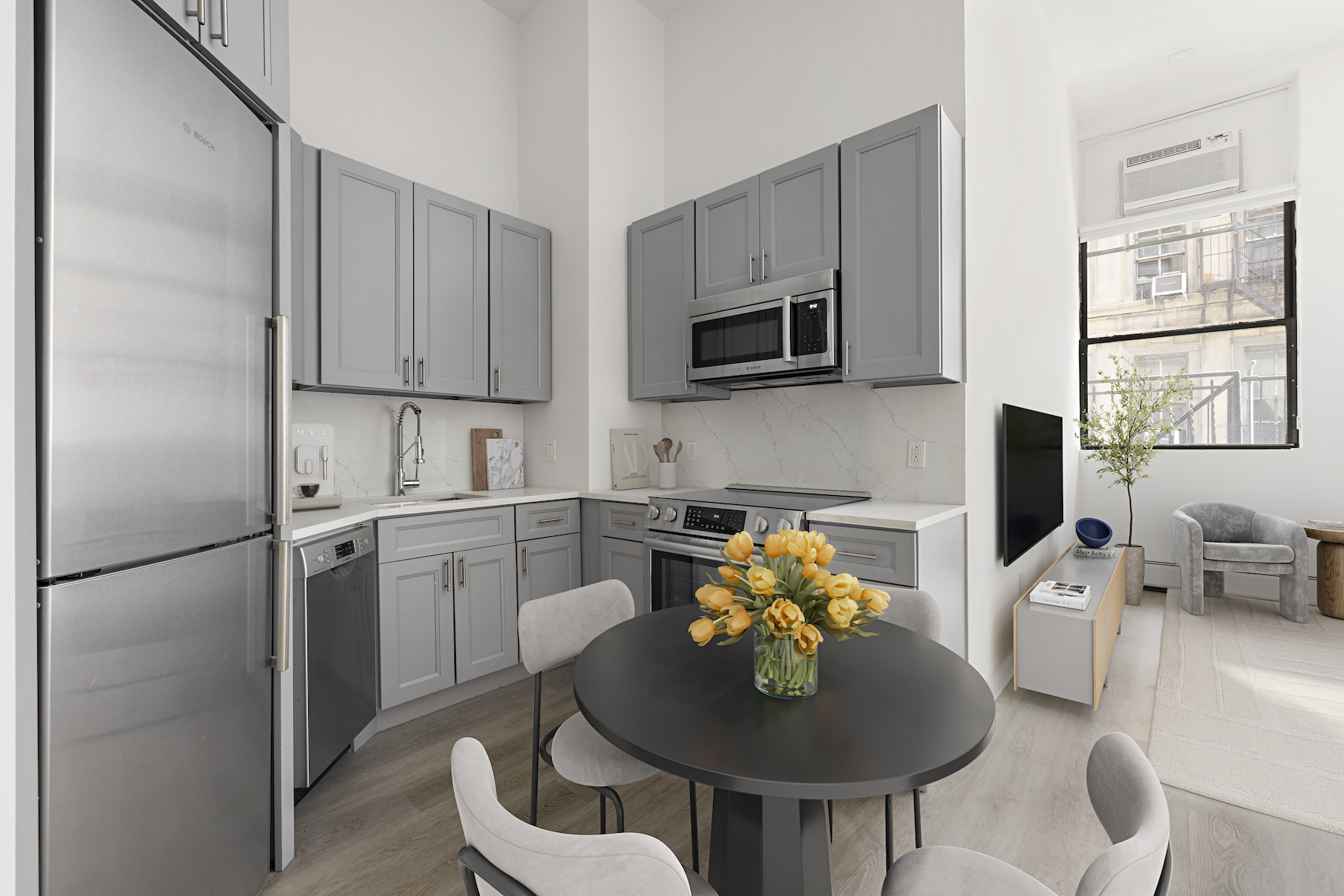 74 Leonard Street, Unit 2D Manhattan, NY 10013 - Photo 3 of 8 a kitchen with stainless steel appliances kitchen island granite countertop a refrigerator a stove a microwave and a dining table with wooden cabinet