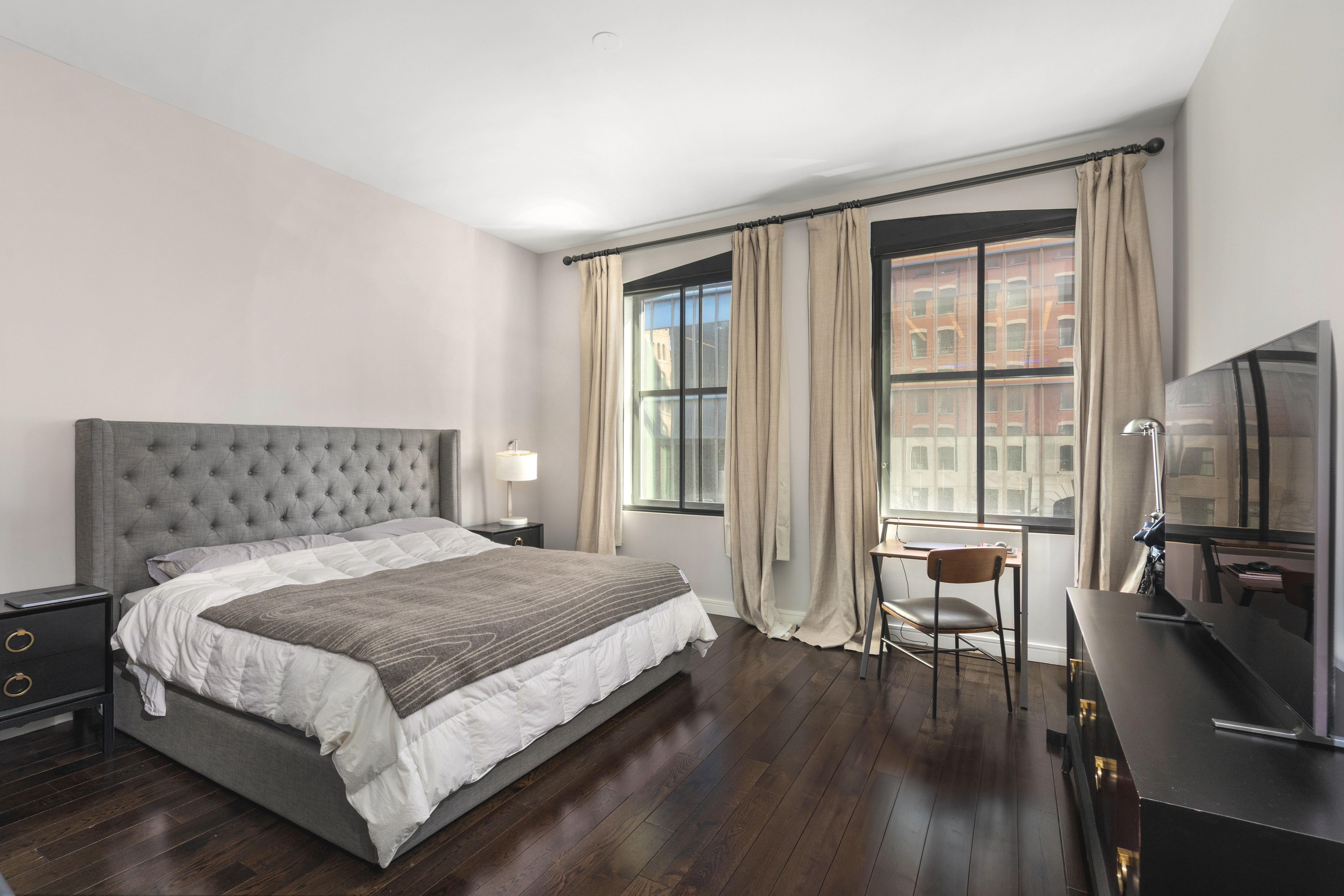 250 West Street, Unit 3F Manhattan, NY 10013 - Photo 4 of 11 a spacious bedroom with a bed and a flat tv screen on the dresser