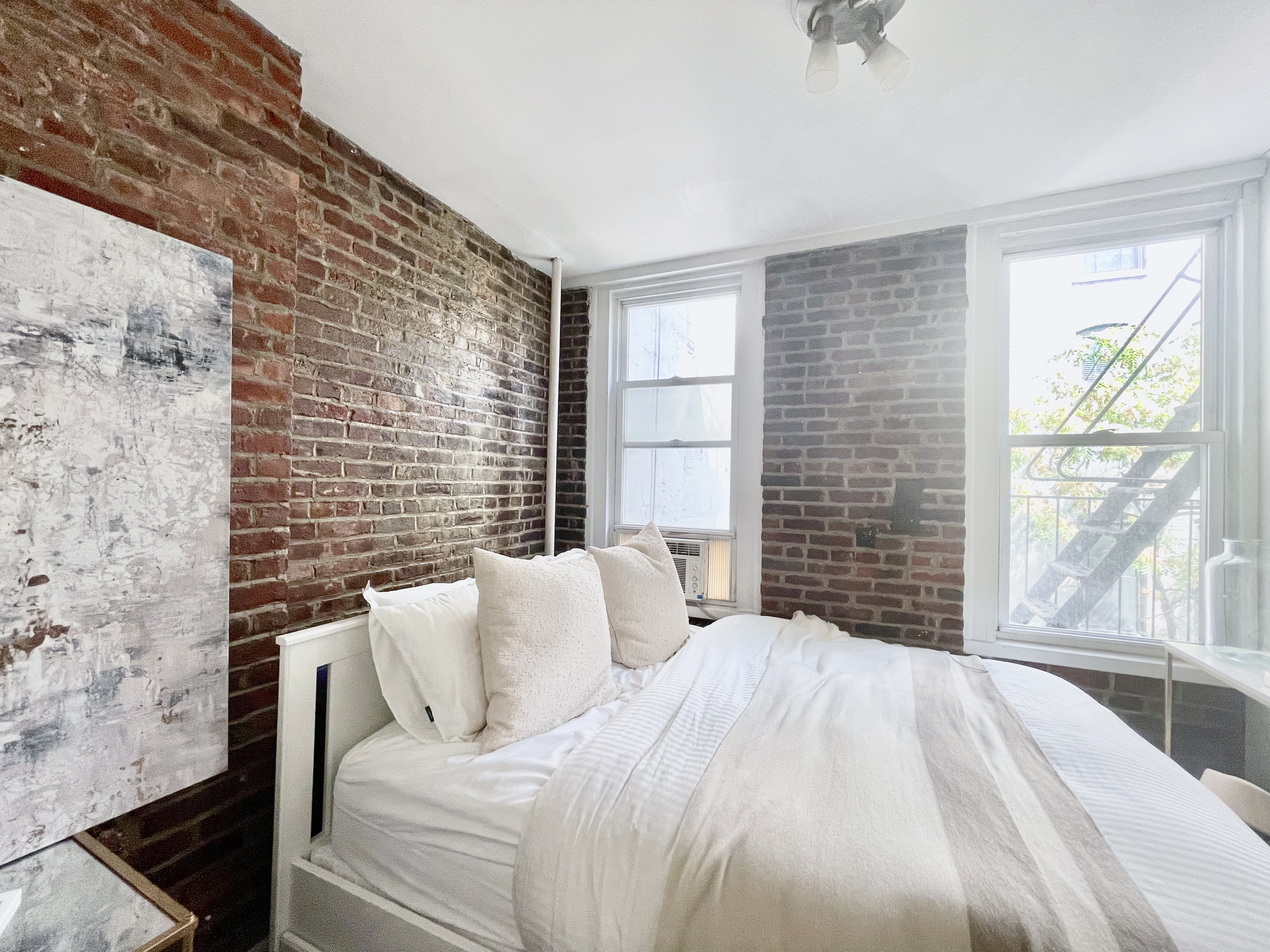 57 Spring Street, Unit 6 Manhattan, NY 10012 - Photo 4 of 10 a bedroom with a bed and a large window