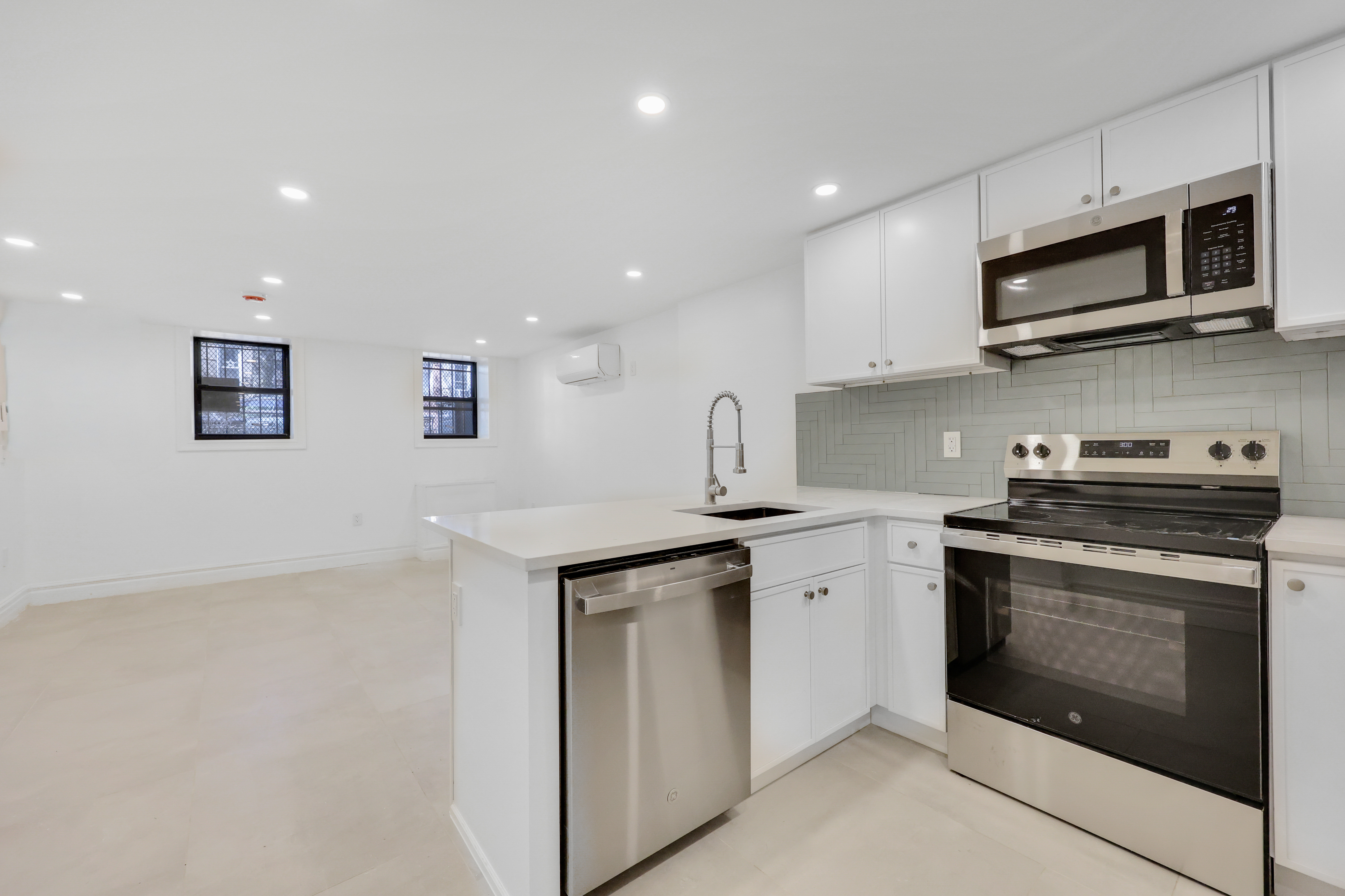 a kitchen with stainless steel appliances granite countertop a sink and a stove top oven with white countertops
