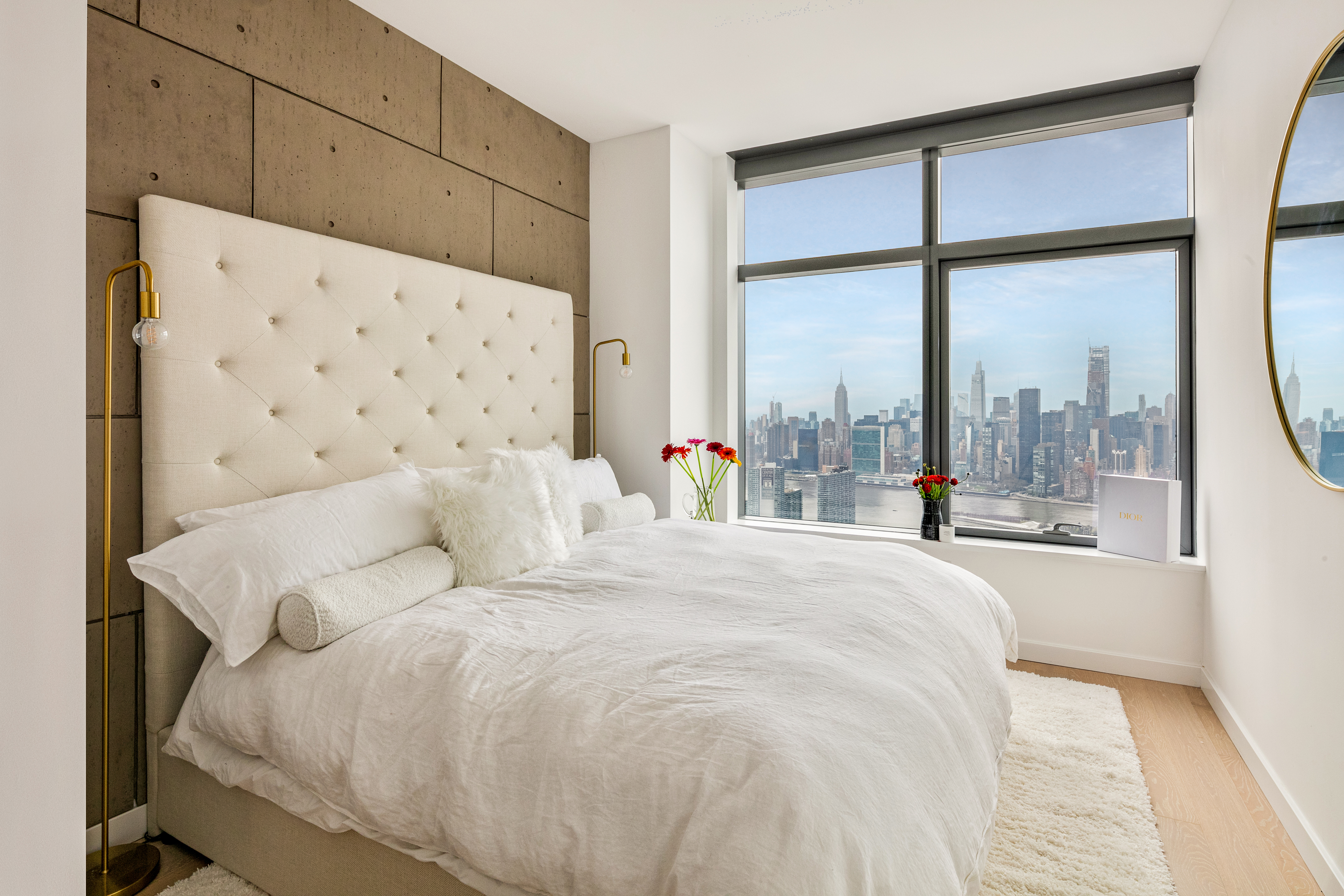 45-3 Ct Square West, Unit PH202 Queens, NY 11101 - Photo 4 of 12 a large white bed sitting in a bedroom next to a window