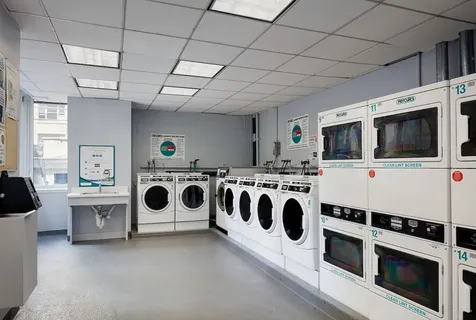 a utility room with stainless steel appliances kitchen island a stove a microwave oven a sink and white cabinets