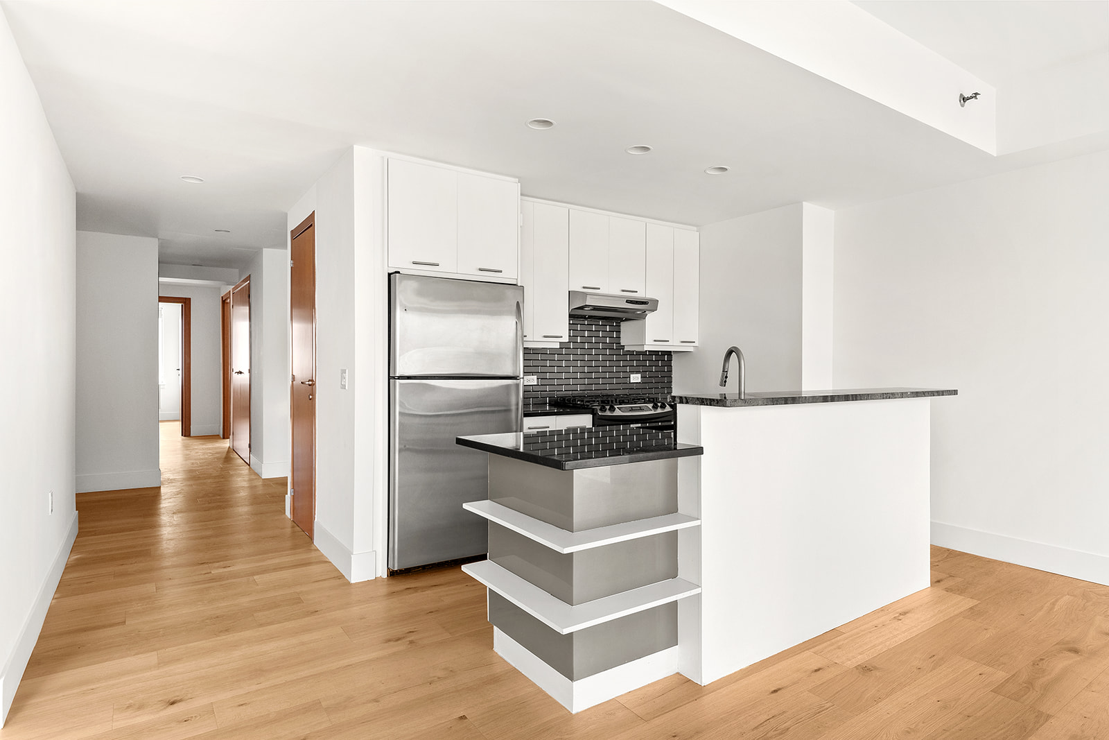 446 Kent Avenue, Unit PHC Brooklyn, NY 11249 - Photo 6 of 22 a kitchen with granite countertop a refrigerator and a stove top oven