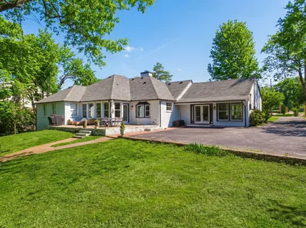 a front view of a house with yard and green space