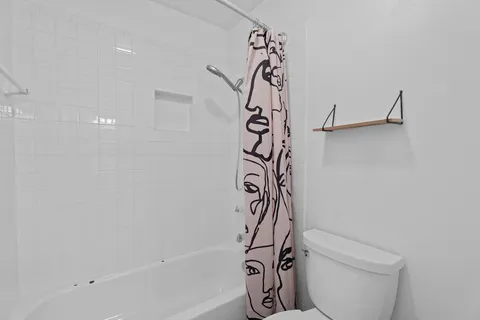 a bathroom with a toilet and a shower