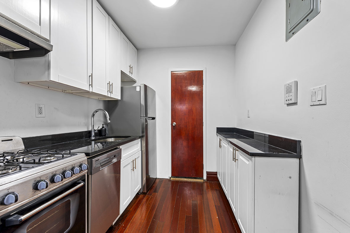 279 East Houston Street, Unit 2B Manhattan, NY 10002 - Photo 3 of 4 a kitchen with granite countertop a stove and a refrigerator