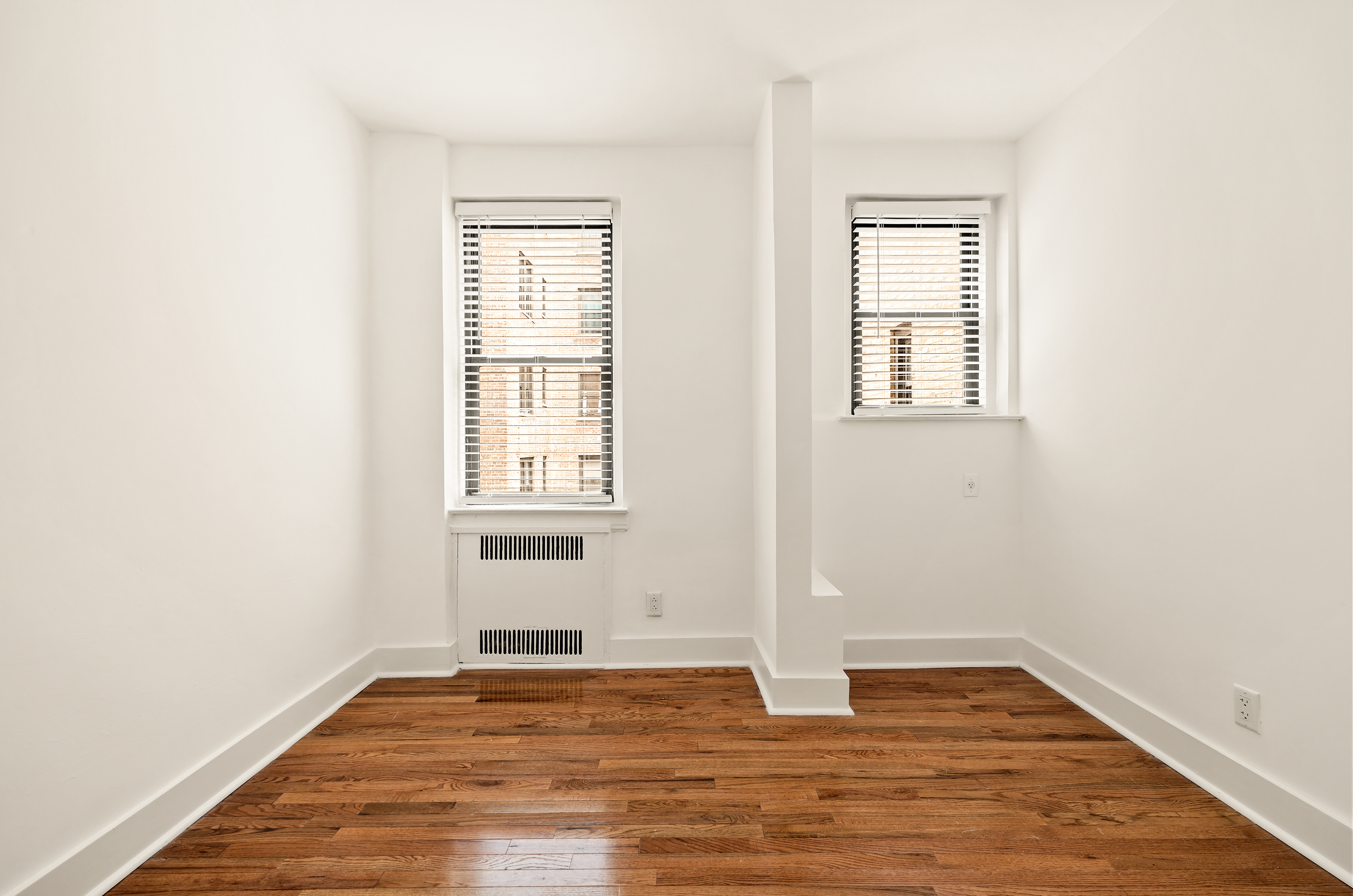 47-39 40th Street, Unit 2G Queens, NY 11104 - Photo 11 of 15 an empty room with wooden floor and windows