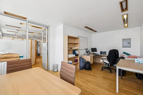 a view of a workspace with furniture and clothes